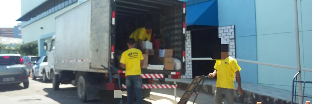 Equipe da Arise Mudanças descarregando um caminhão baú em frente a um prédio