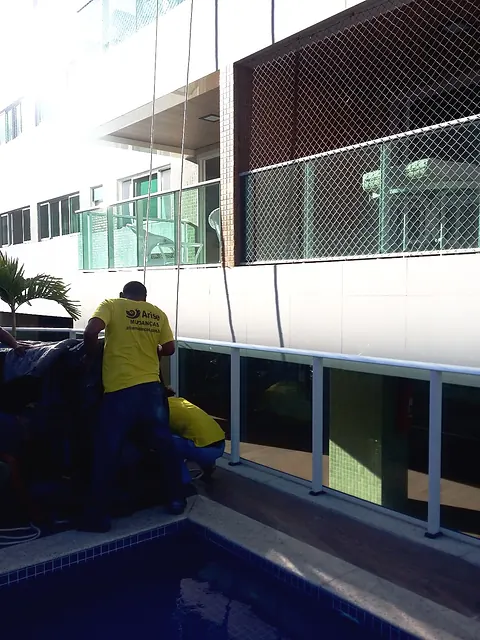 Equipe da Arise carregando volumes em uma residência com piscina