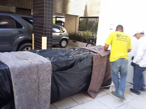Colchão e móveis embalados aguardando carregamento na entrada do prédio