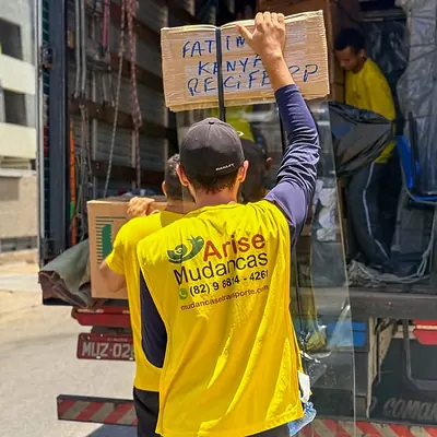 Caixas identificadas sendo carregadas no baú do caminhão para mudança interestadual