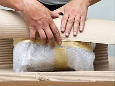 Mãos aplicando plástico-bolha em um móvel antes do transporte